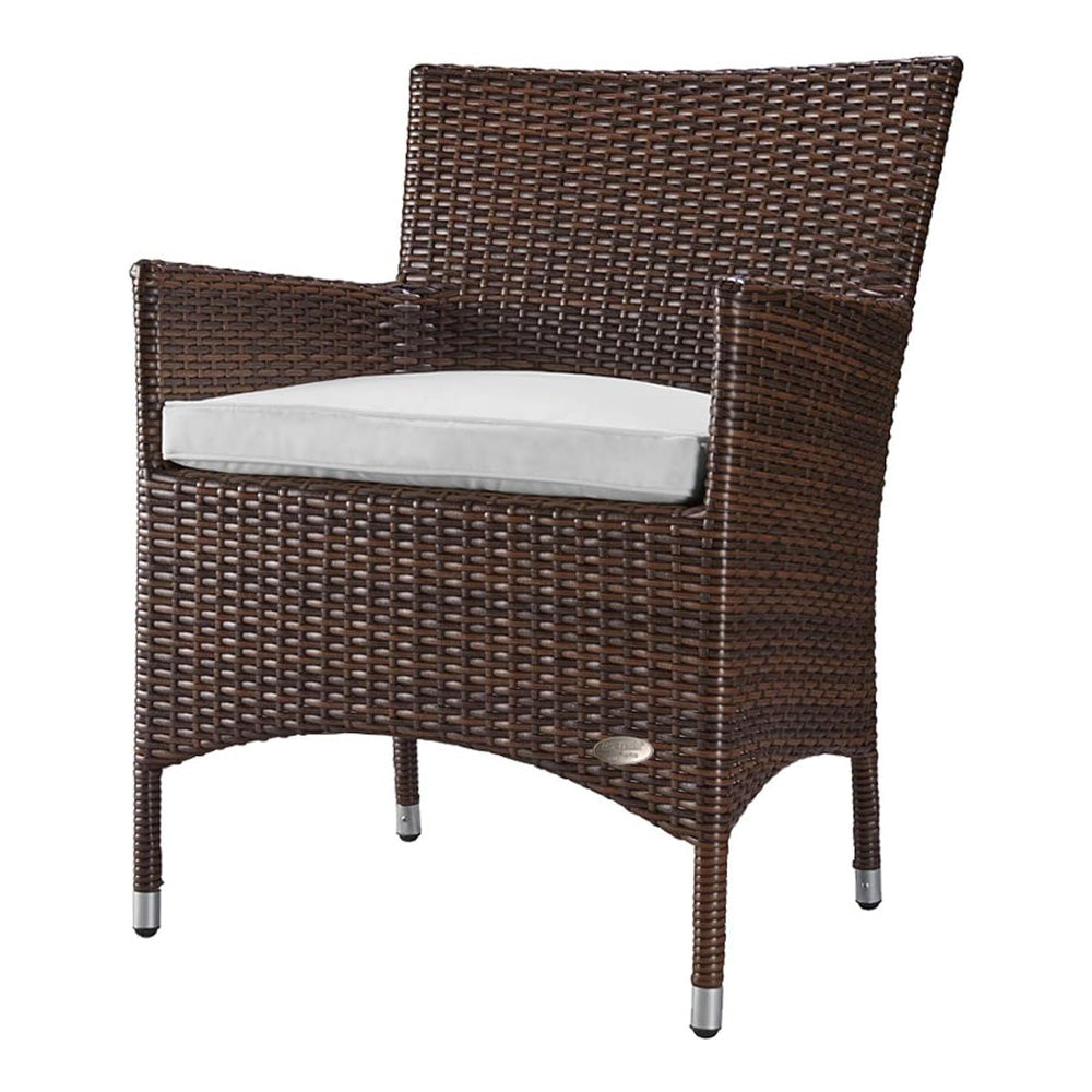 Brauner Rattanstuhl mit Armlehnen und weißem Sitzkissen aus wetterfestem Kunststoffgeflecht.