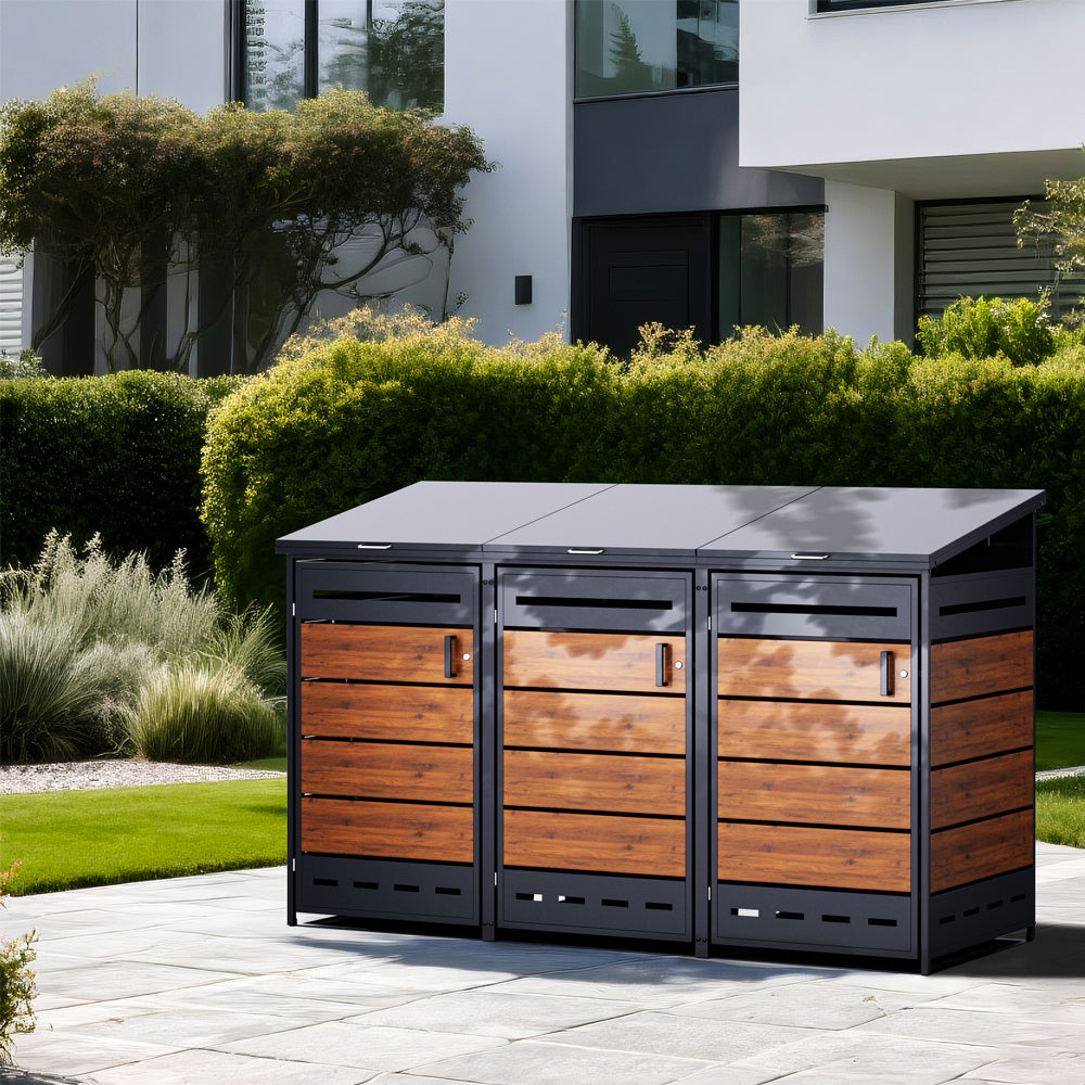 Dreifache Mülltonnenbox aus Metall und Holzoptik, aufgestellt neben einem modernen Haus.
