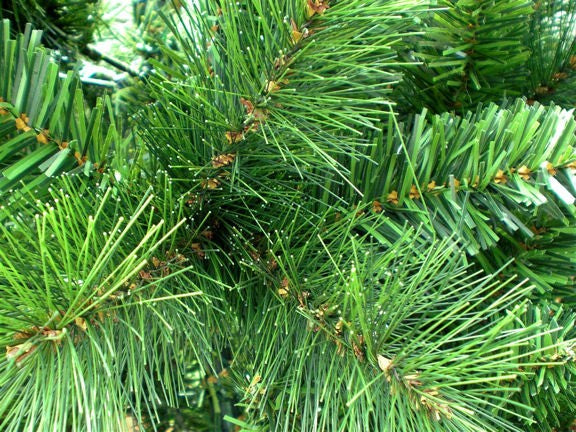 Nahaufnahme grüner Tannenzweige eines künstlichen Weihnachtsbaums mit feinen Nadeln. 195 cm
