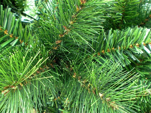 Nahaufnahme von kuenstlichen Tannenzweigen mit gruenen, unterschiedlich langen Nadeln. SLIM 270 cm