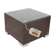 Freigestellter quadratischer Beistelltisch aus braunem Polyrattan mit Glasplatte und Metallfüßen vor weißem Hintergrund.