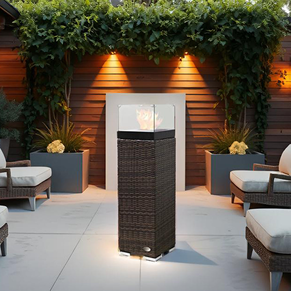 Feuersäule brennt stimmungsvoll auf Terrasse, umgeben von Gartenmöbeln und Pflanzen.