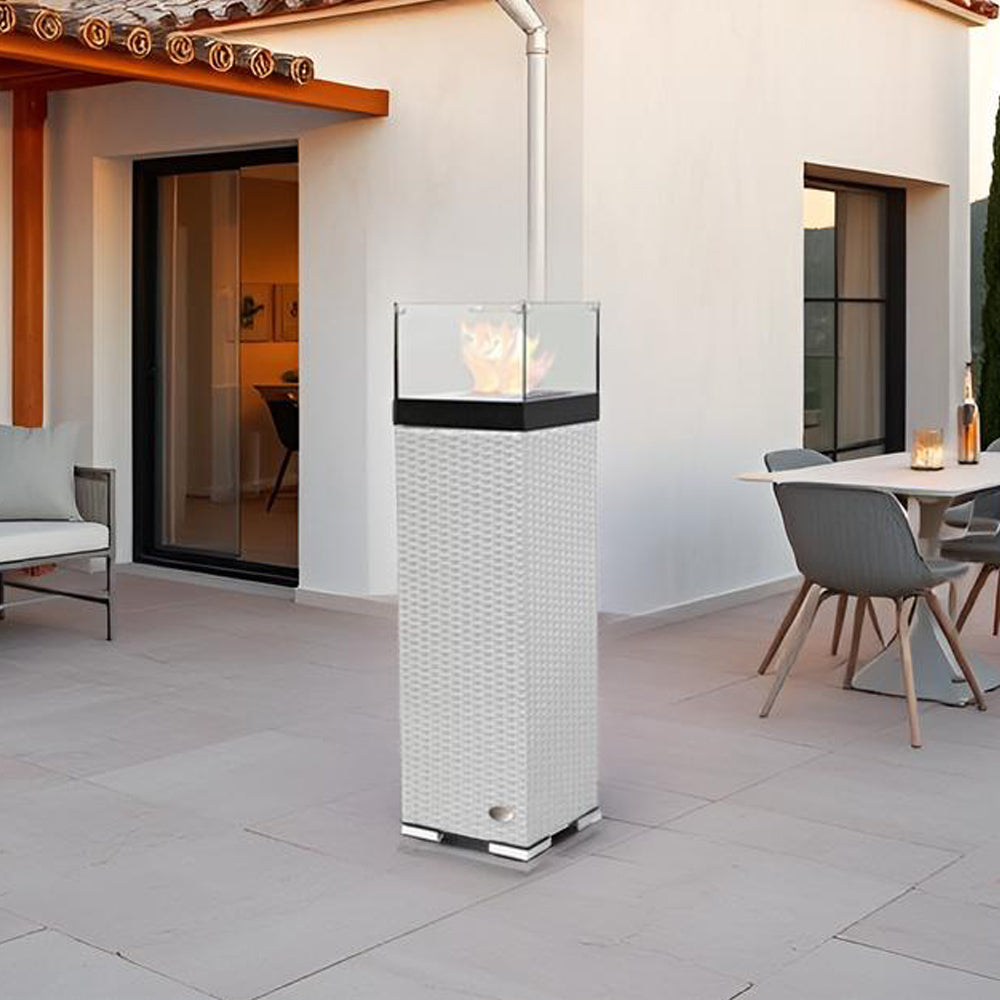 Feuersäule auf Terrasse vor Hausfassade, stilvoll dekoriert mit Essbereich im Hintergrund.