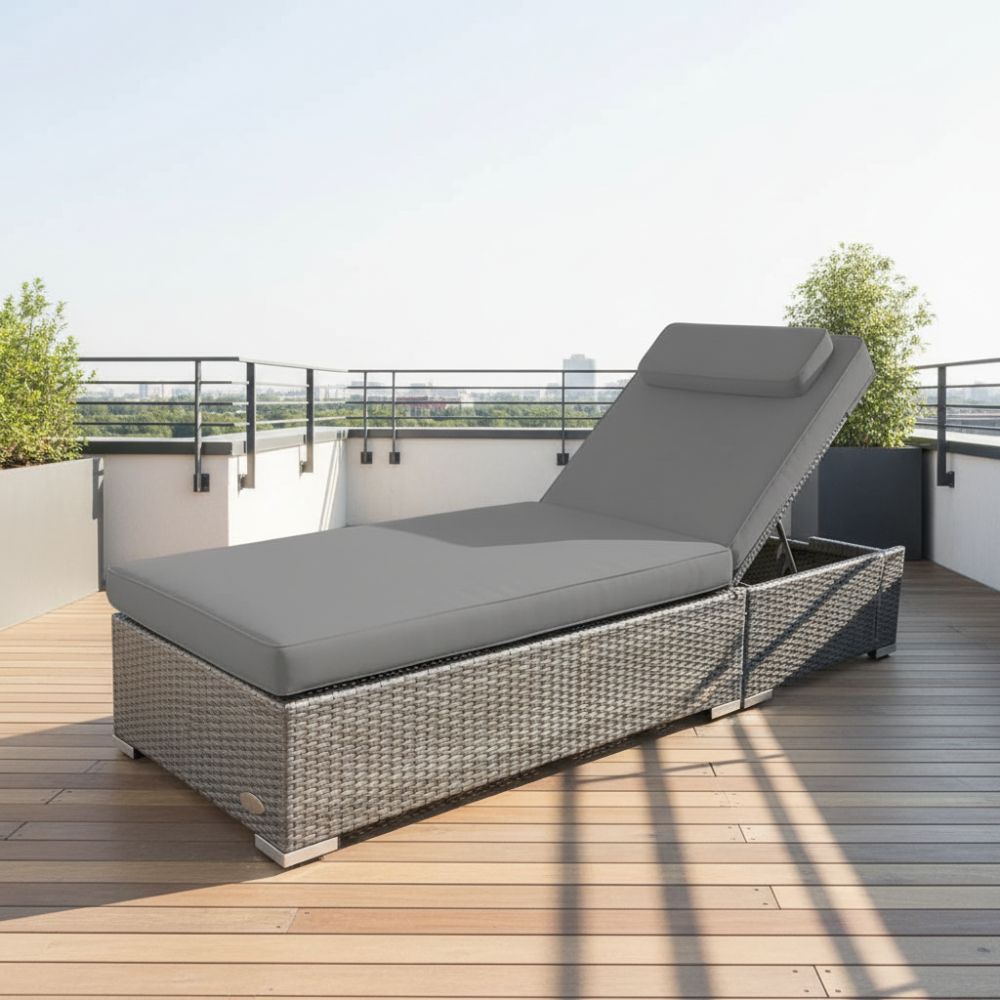 Graue Gartenliege aus Polyrattan mit gepolsterter Auflage und verstellbarer Rückenlehne auf einer sonnigen Dachterrasse