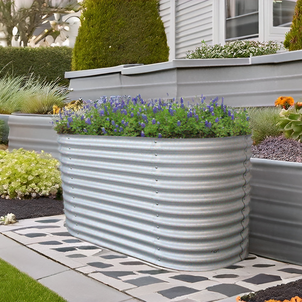 Ovales Hochbeet mit Lavendel auf Terrasse, im Hintergrund weitere Pflanzkübel.