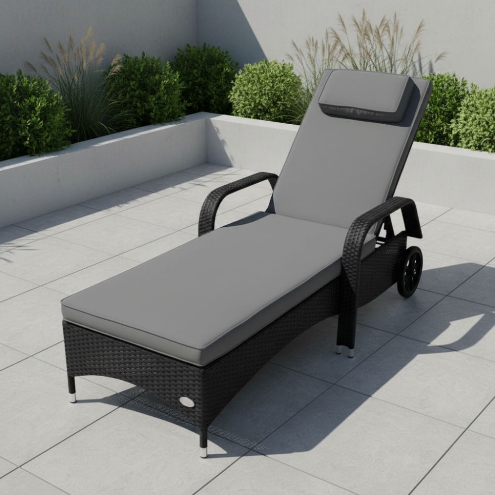 Schwarze Polyrattan Sonnenliege mit grauer 7 cm dicker Komfortauflage und Kopfkissen auf Terrasse