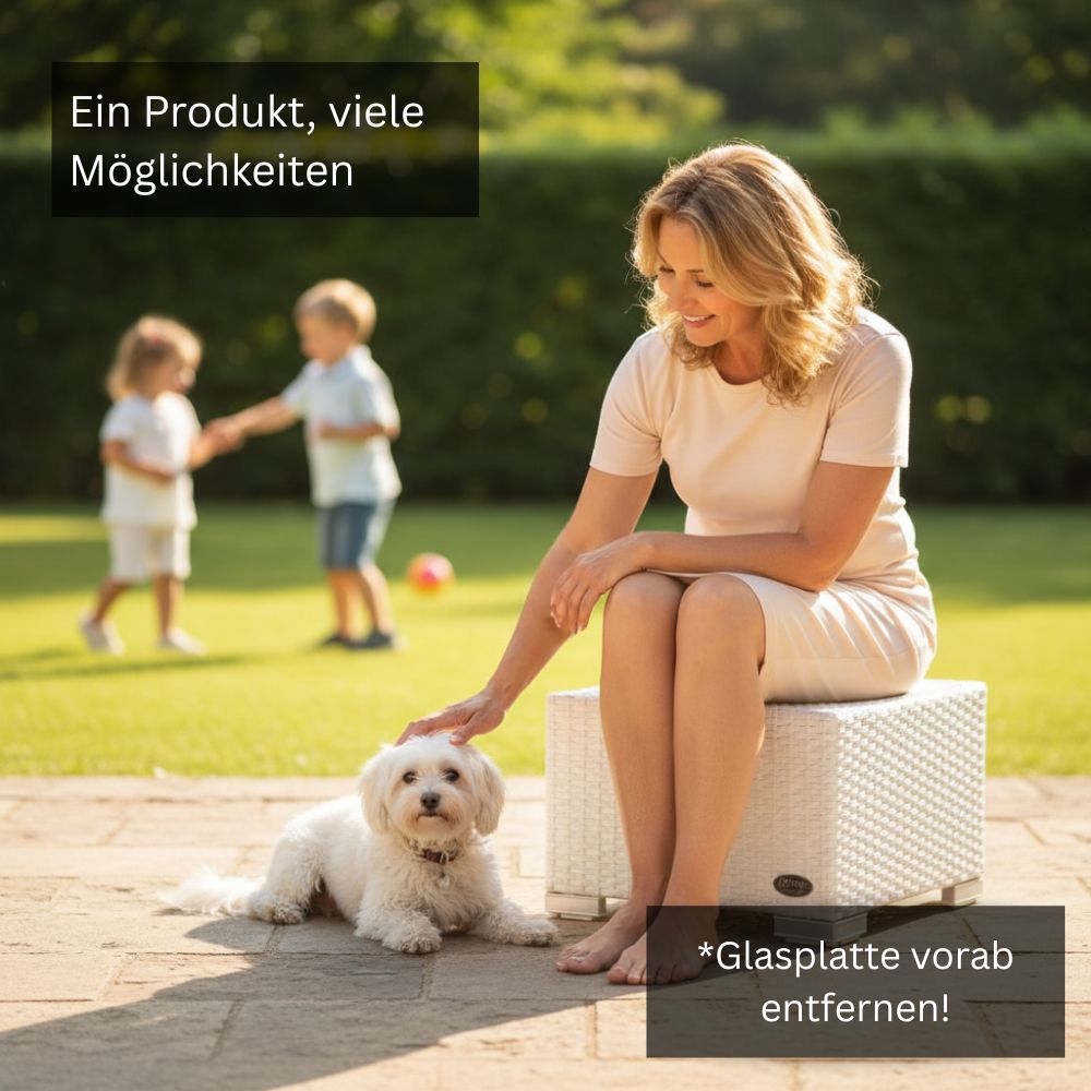 Frau sitzt auf einem weißen Polyrattan-Beistelltisch im Garten, daneben liegt ein kleiner weißer Hund.