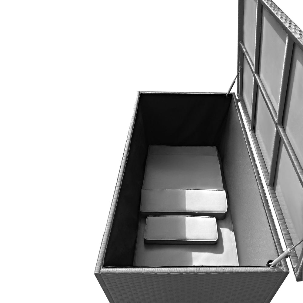 Geöffnete silber/graue Aufbewahrungsbox in Rattan-Optik mit innenliegenden Polstern. Der Deckel wird von zwei Gasdruckdämpfern gehalten.