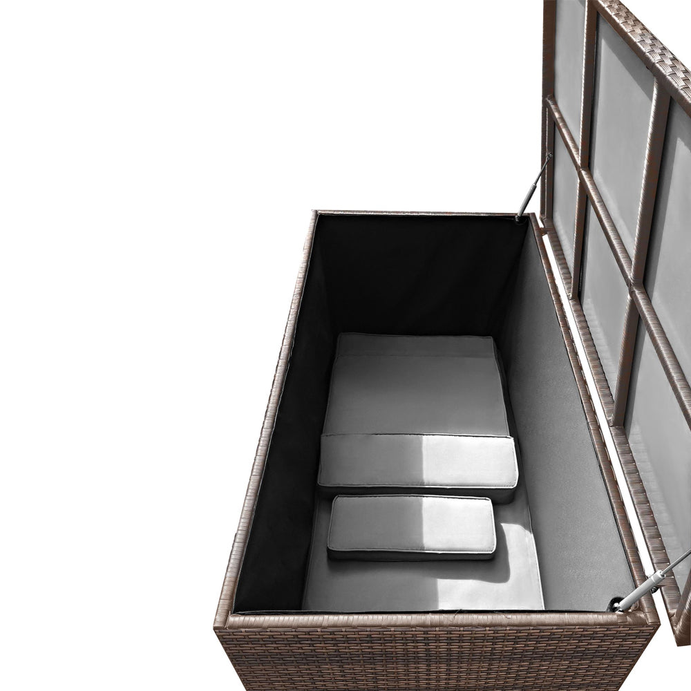 Geöffnete braune Aufbewahrungsbox in Rattan-Optik mit innenliegenden Polstern. Der Deckel wird von zwei Gasdruckdämpfern gehalten.
