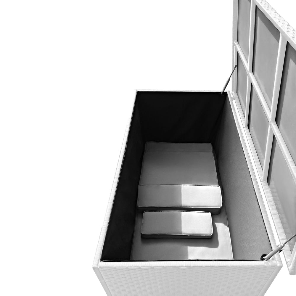 Geöffnete weiße Aufbewahrungsbox in Rattan-Optik mit innenliegenden Polstern. Der Deckel wird von zwei Gasdruckdämpfern gehalten.