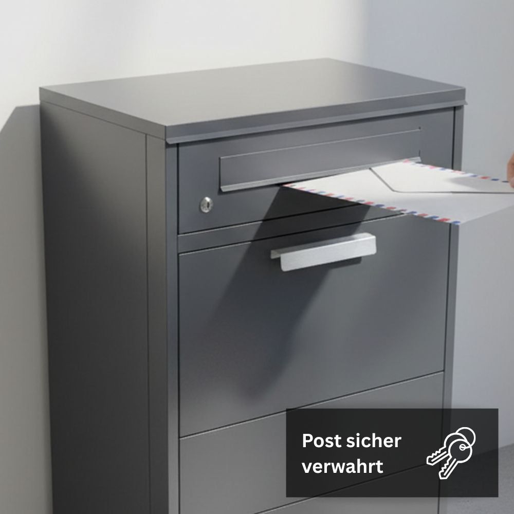 Anthrazitfarbener Briefkasten mit integriertem Paketfach und geöffneter Einwurfklappe. Ein Brief wird in das obere Brieffach eingeworfen. Der Paketbriefkasten besteht aus pulverbeschichtetem Stahl und ist für den Außenbereich geeignet.