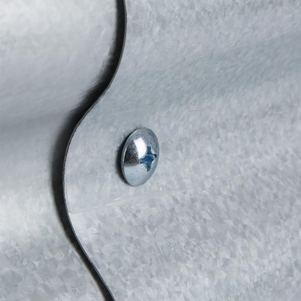 Nahaufnahme einer verschraubten Blechkante aus verzinktem Metall mit Kreuzschlitzschraube.