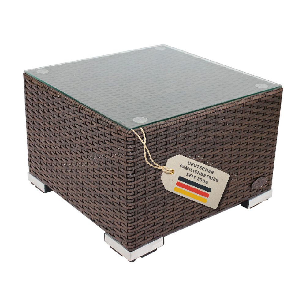 Freigestellter quadratischer Beistelltisch aus braunem Polyrattan mit Glasplatte und Metallfüßen vor weißem Hintergrund.