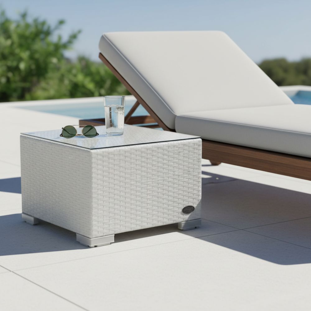 Weißer Polyrattan-Beistelltisch mit Glasplatte neben einer Gartenliege am Pool.