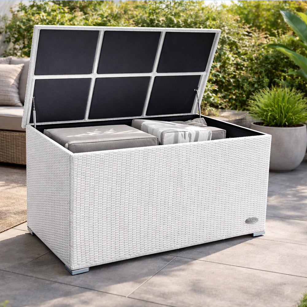 Weiße Garten-Auflagenbox aus wetterfestem Polyrattan auf der Terrasse mit geöffnetem Deckel und verstauten Sitzkissen im Innenraum.