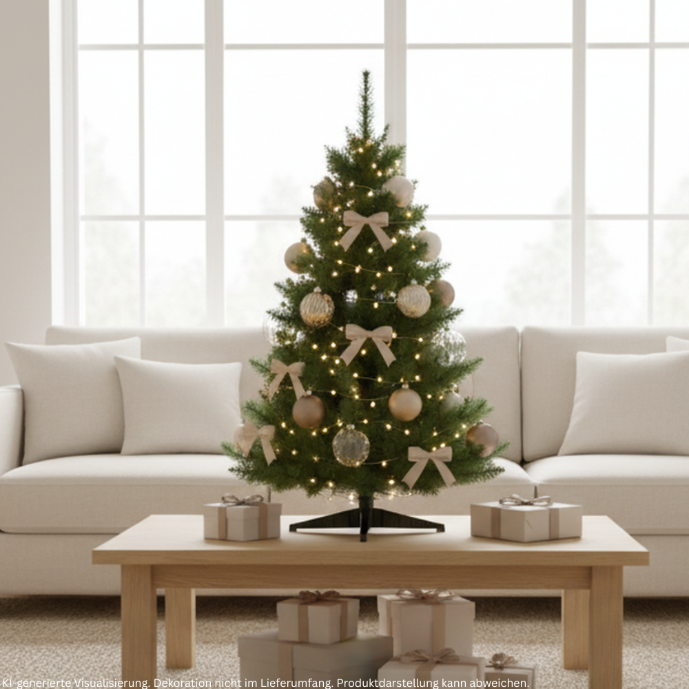 Grüner künstlicher Weihnachtsbaum mit warmweißer Lichterkette, goldenen Kugeln und Schleifen auf einem Wohnzimmertisch.