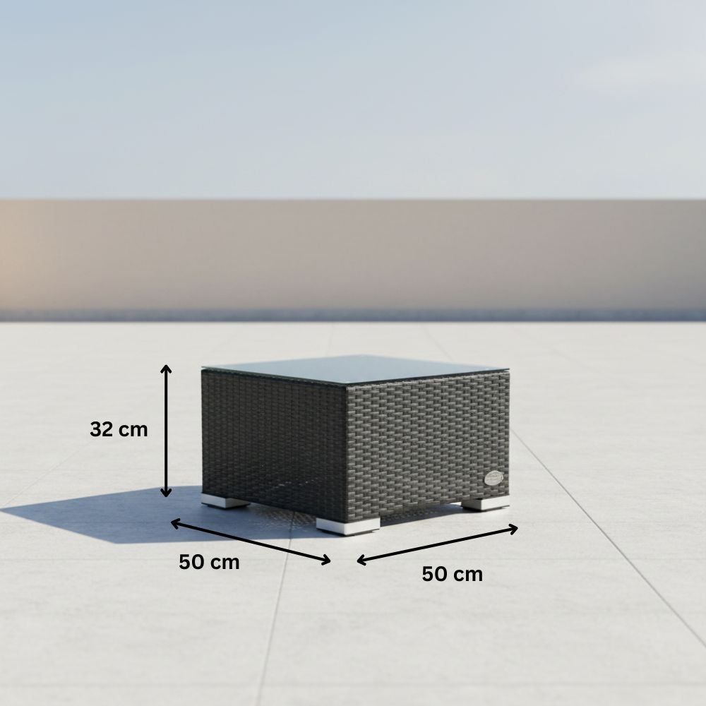 Quadratischer Beistelltisch aus schwarzem Polyrattan mit Glasplatte. Die Maße des Tisches betragen 50 × 50 × 32 Zentimeter.