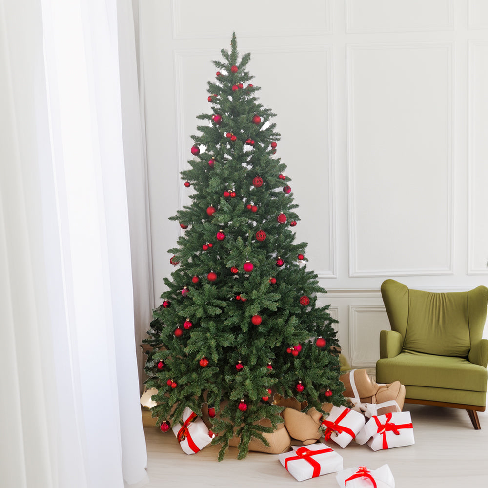 Weihnachtsbaum mit roten Kugeln geschmückt, darunter weiße Geschenke mit roten Schleifen.