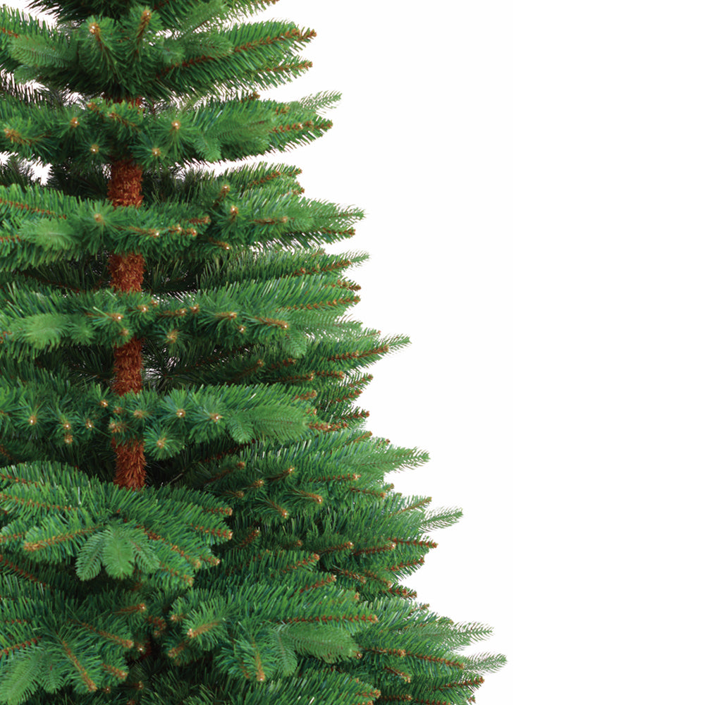 Künstlicher Weihnachtsbaum mit dichten grünen Nadeln und braunem Stamm in Nahaufnahme. 270 cm