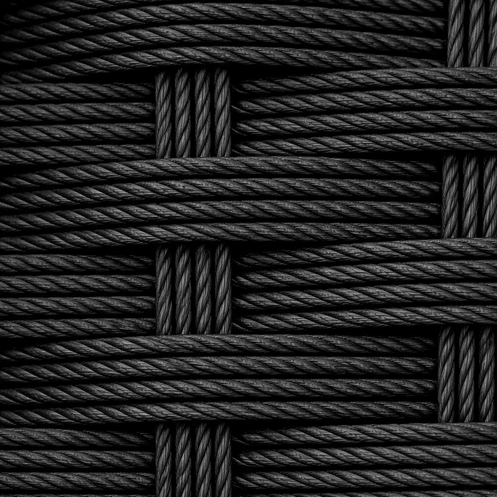 Nahaufnahme eines schwarzen Polyrattan-Geflechts mit strukturierter Oberfläche.