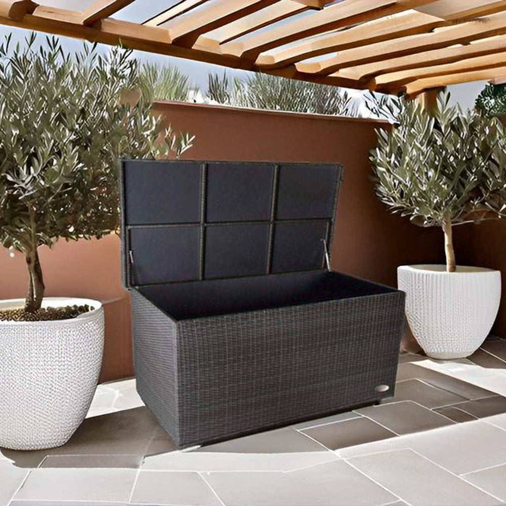 Venezia-Box mit offenem Deckel auf Terrasse unter Pergola, flankiert von weißen Pflanztöpfen.
